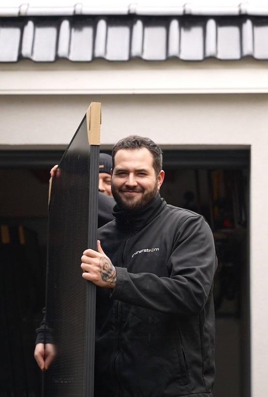 grunerstrom-mitarbeiter-pv-modul-sized grunerstrom mitarbeiter mit photovoltaikmodul